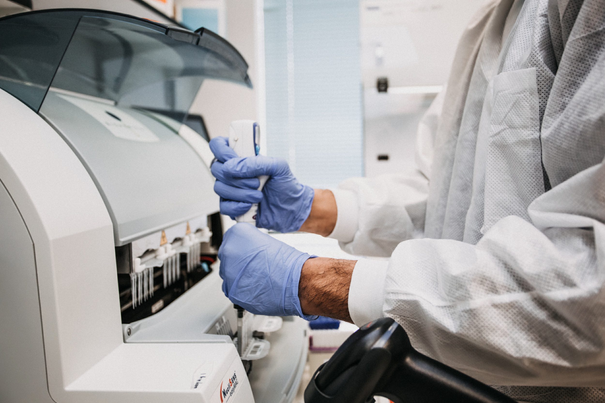 Medical laboratory technician using testing equipment